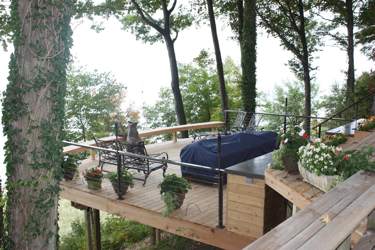 A custom deck design in Fennville, Michigan. The deck offers a treehouse vibe as its elevated among natural cedar.