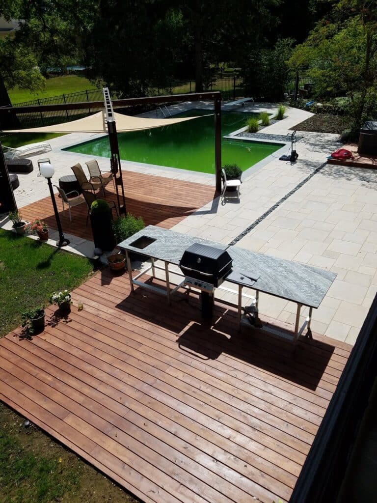 Precision knows the carpenter vs contractor debate well. While one is good for small projects, our team can design a more complete project. A backyard with two separate deck platforms, one with a sail covering patio furniture, the other with a grilling station.