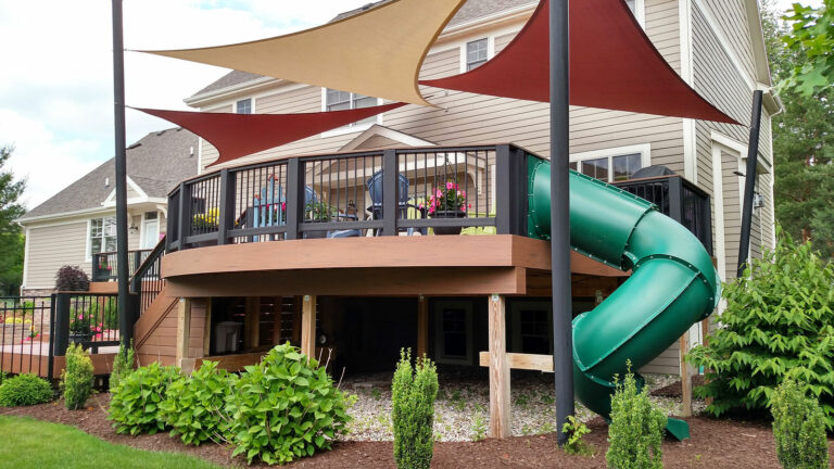 Deck safety rails are vital when the intent is for chirldren to use it. A deck with a tunnel slide going from upper deck to lower area.