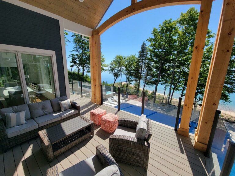 A unqie patio design overlooking a pool along a lakeshore house.