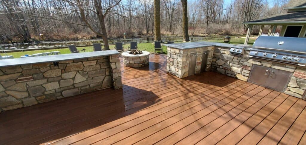 Photo of a custom deck with a fire pit and outdoor kitchen.