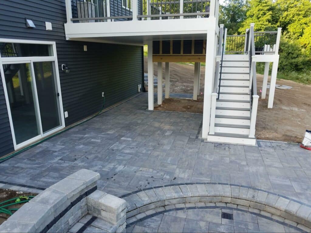 Photo of elevated deck with stairs, and a patio made of Flagstone pavers.