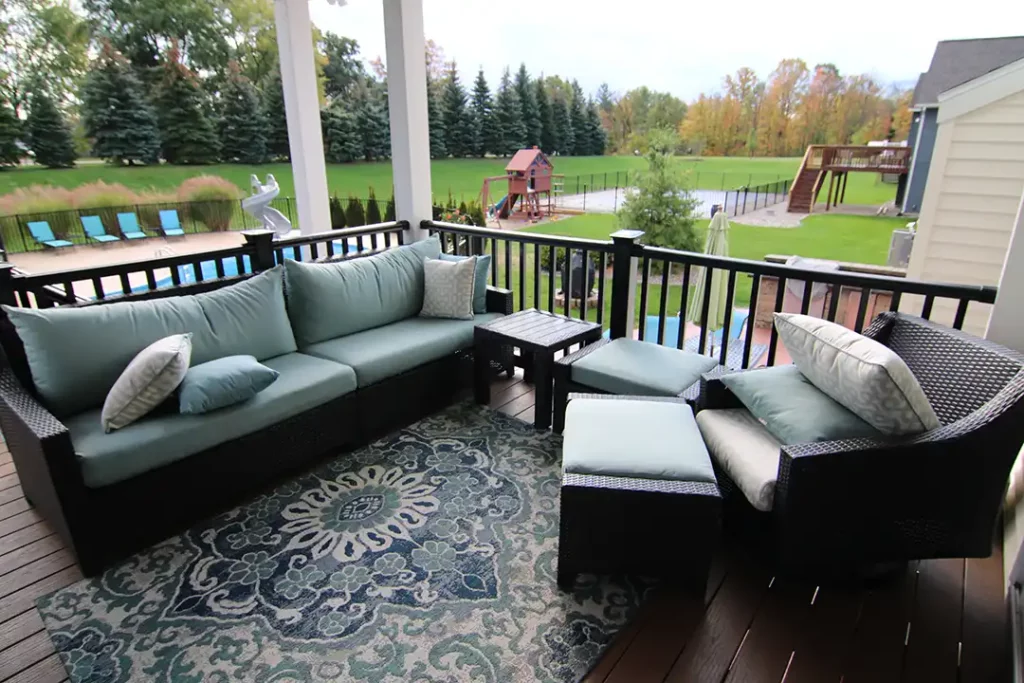 Photo of a covered back porch with outdoor furniture and railing precision decks and patios