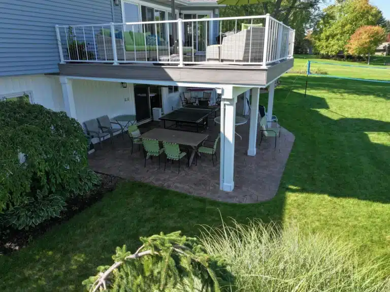 elevated deck with patio underneath that features an underdeck drainage system