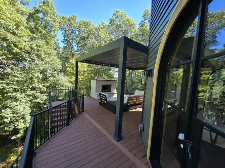 photo of elevated deck with louvered roof pergola, outdoor fireplace, deck railing, and deck steps