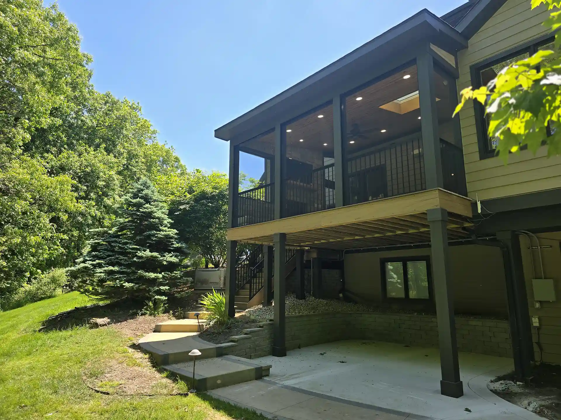 photo of an elevated deck with screen room and a concrete patio below