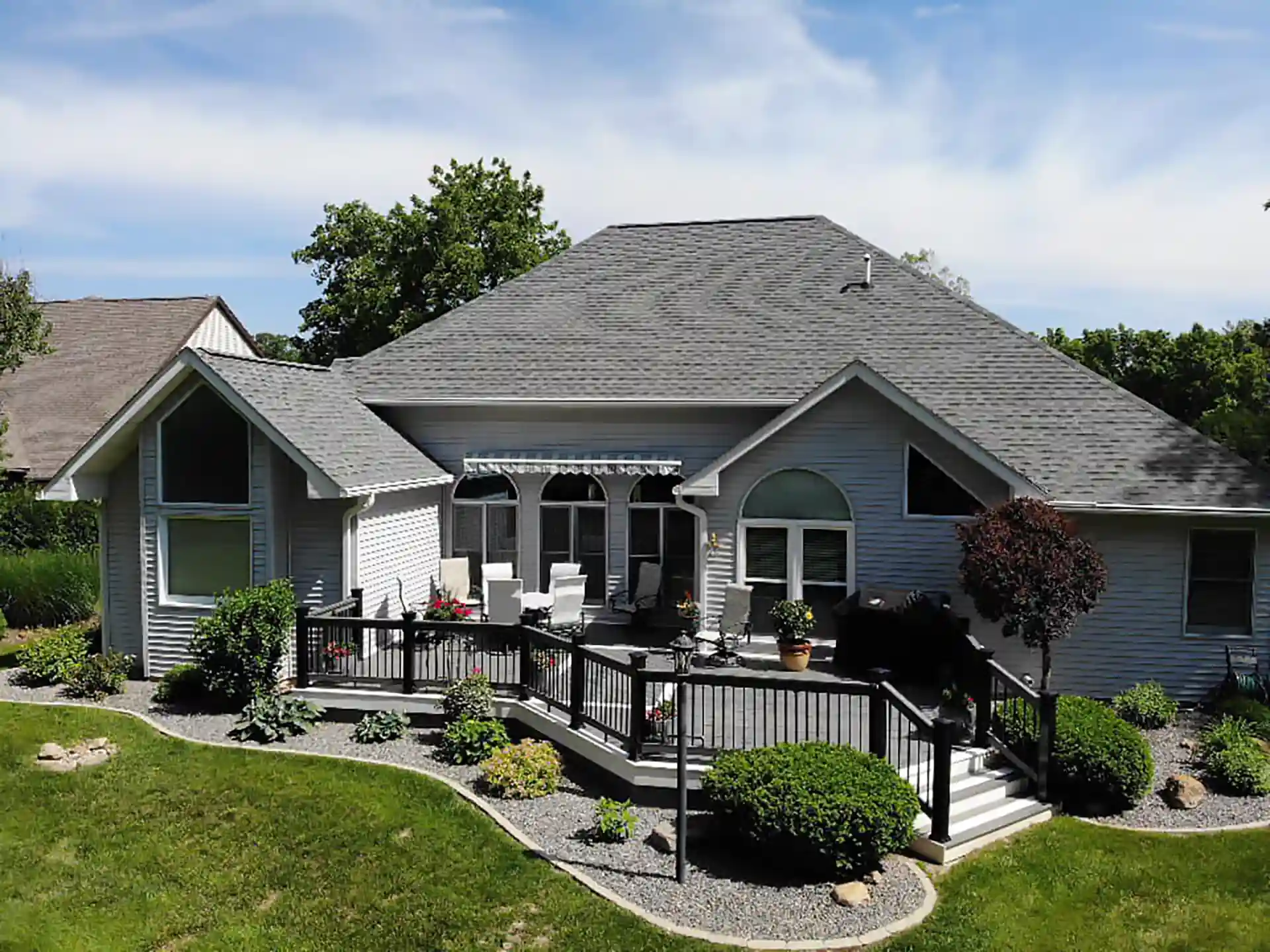 photo of a home exterior with a raised deck and deck railing