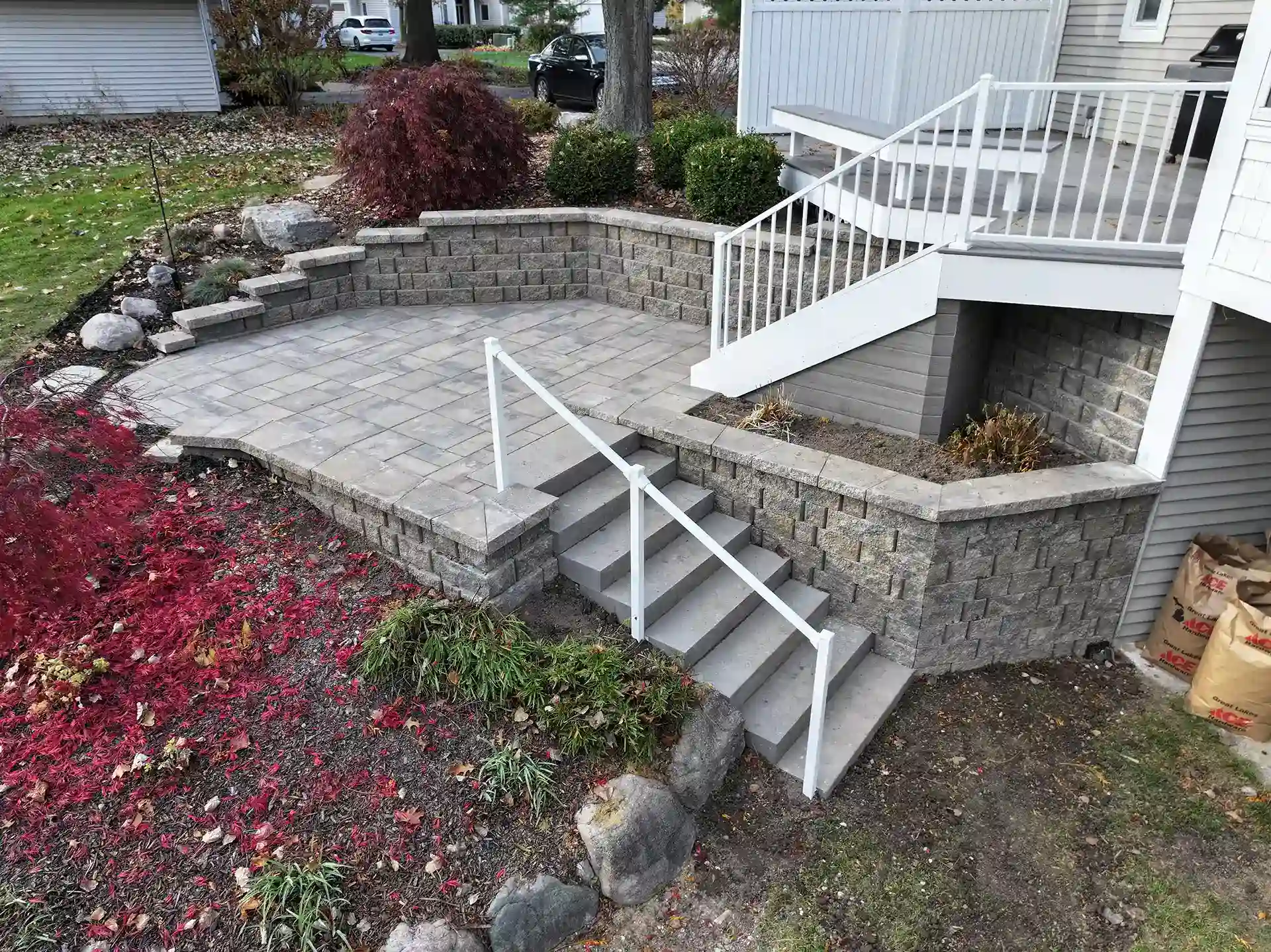 photo of a custom deck that leads down to a small paver patio