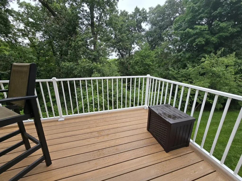 Corner view of AZEK deck with white Westbury railings and lush backyard scenery