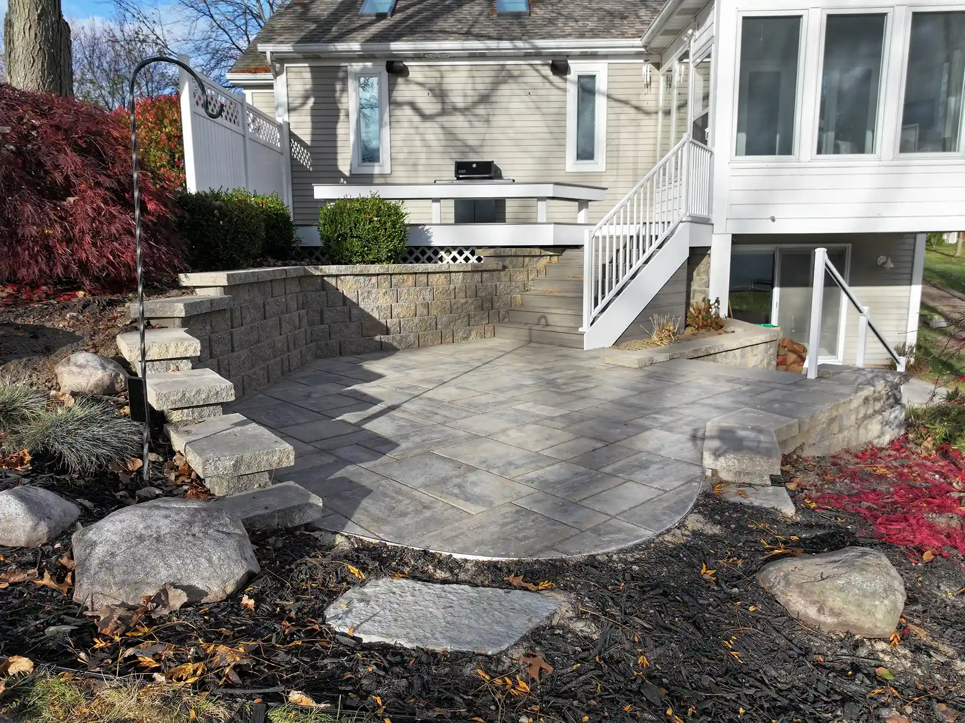 photo of a custom sunroom, retaining wall, and patio
