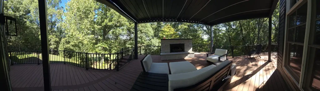 Cozy seating area under pergola with built-in lighting and fireplace.