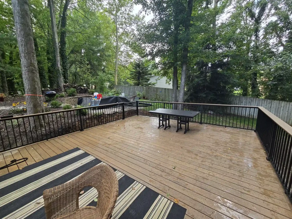 Wide view of the spacious deck with outdoor furniture and black metal railings.