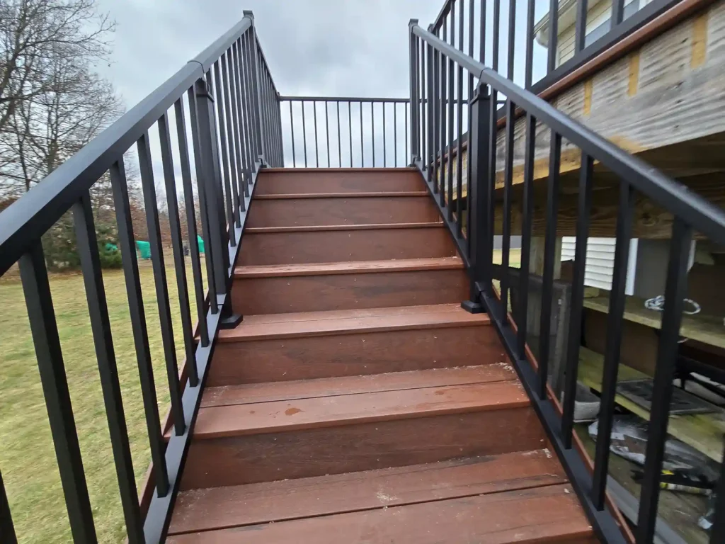 photo of New staircase with rich-toned composite steps and black railings