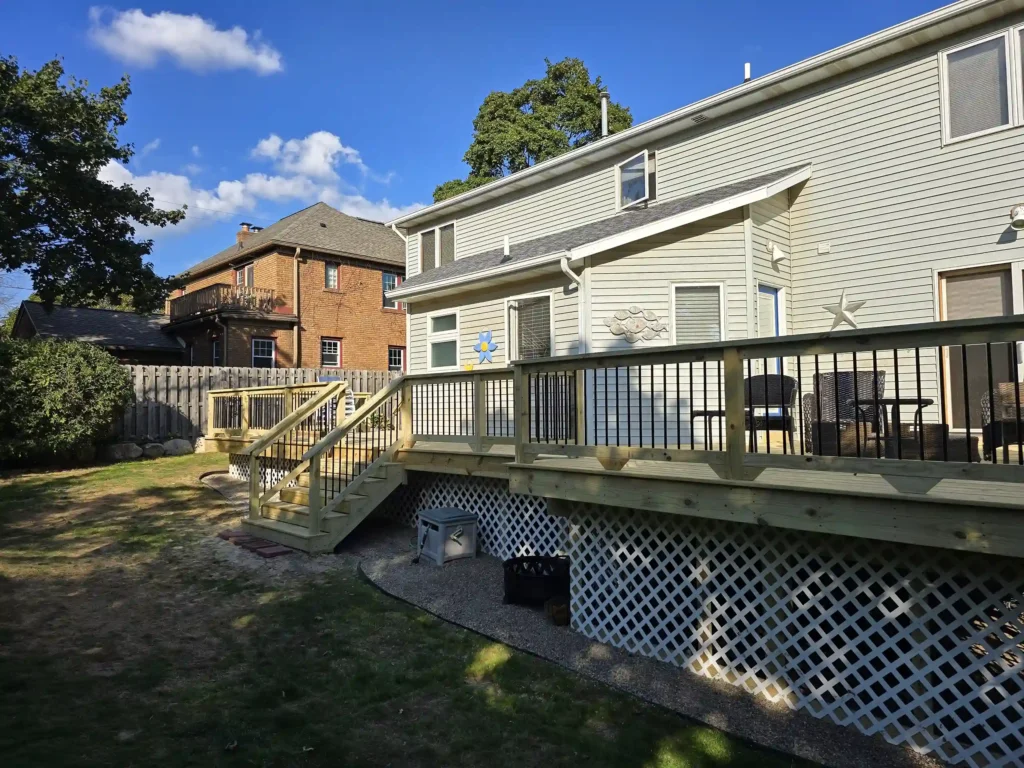 Long shot of Newly built treated wood deck with black aluminum railings and lattice skirting