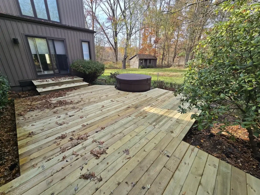 photo of Newly built back deck with pressure-treated wood and a hot tub.