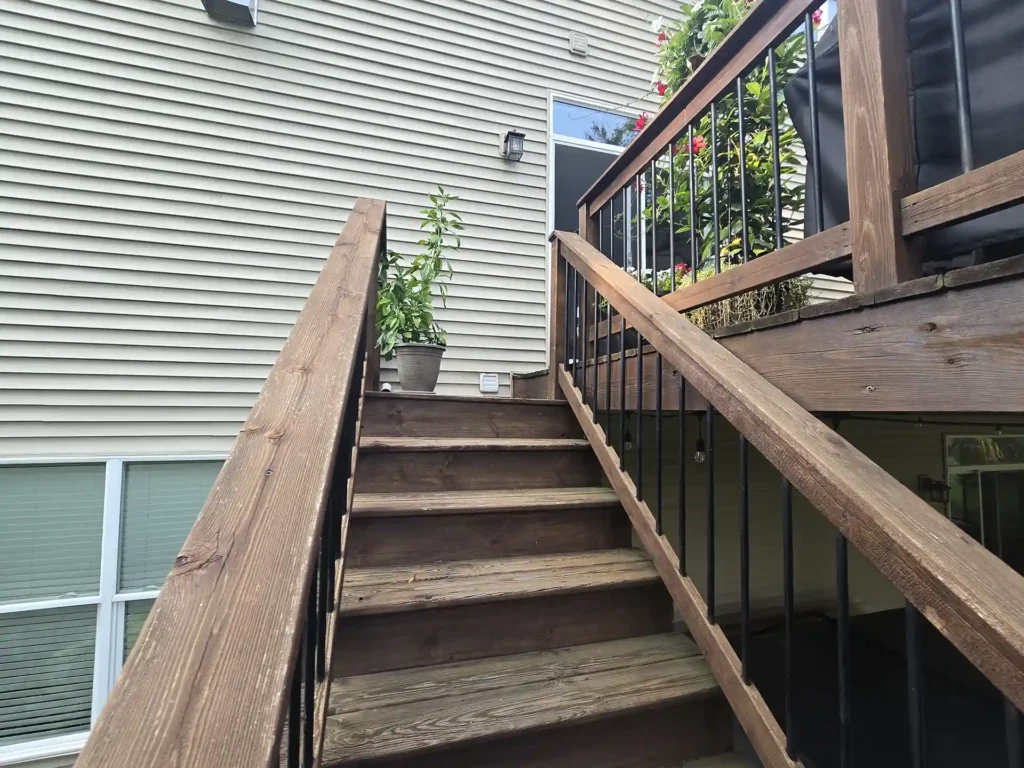 photo of Underside of the deck showing aging wood and staircase structure.