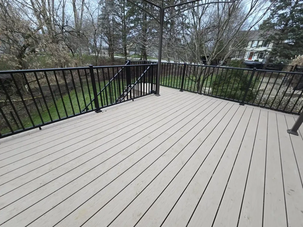 photo of Spacious deck surface with light-toned composite decking and sleek black railings