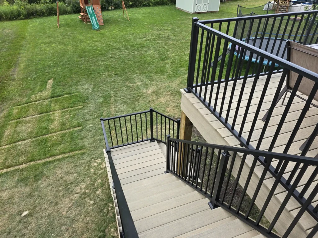 Side view of an elevated deck with stairs leading to the backyard.