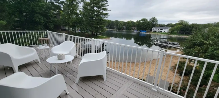 PHoto of an elevated deck with outdoor furniture overlooking a body of water.