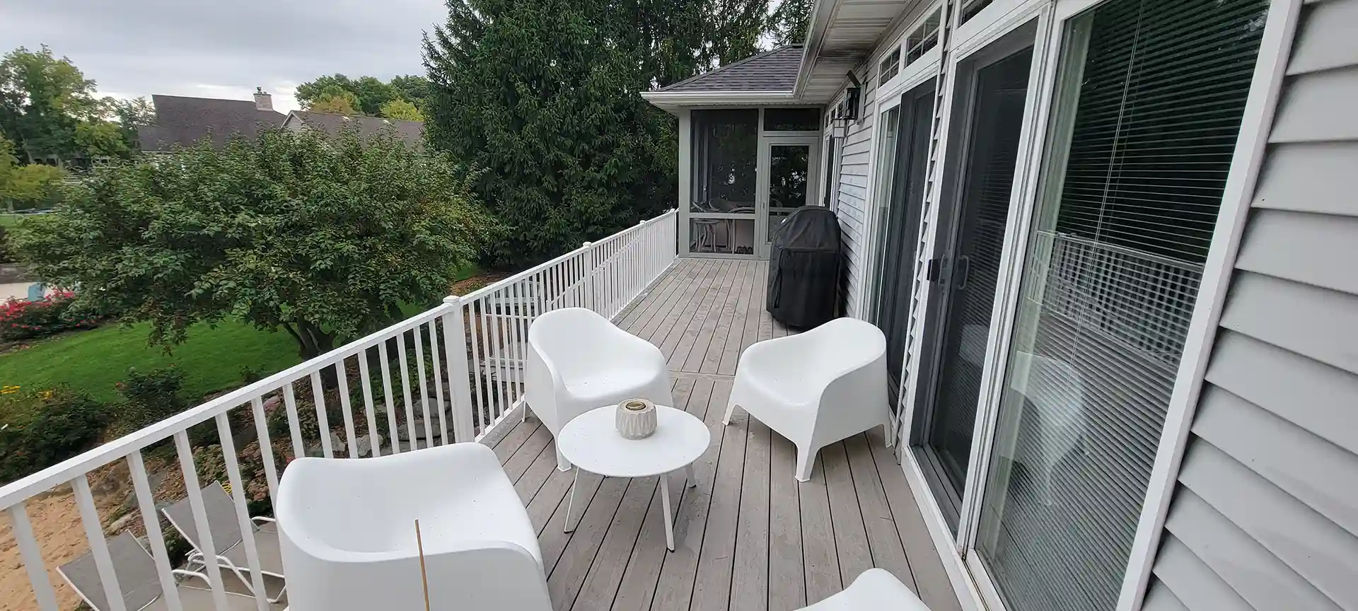 PHoto of an elevated composite deck with outdoor furniture. Our deck maintenance checklist recommends moving the furniture to avoid discoloration.