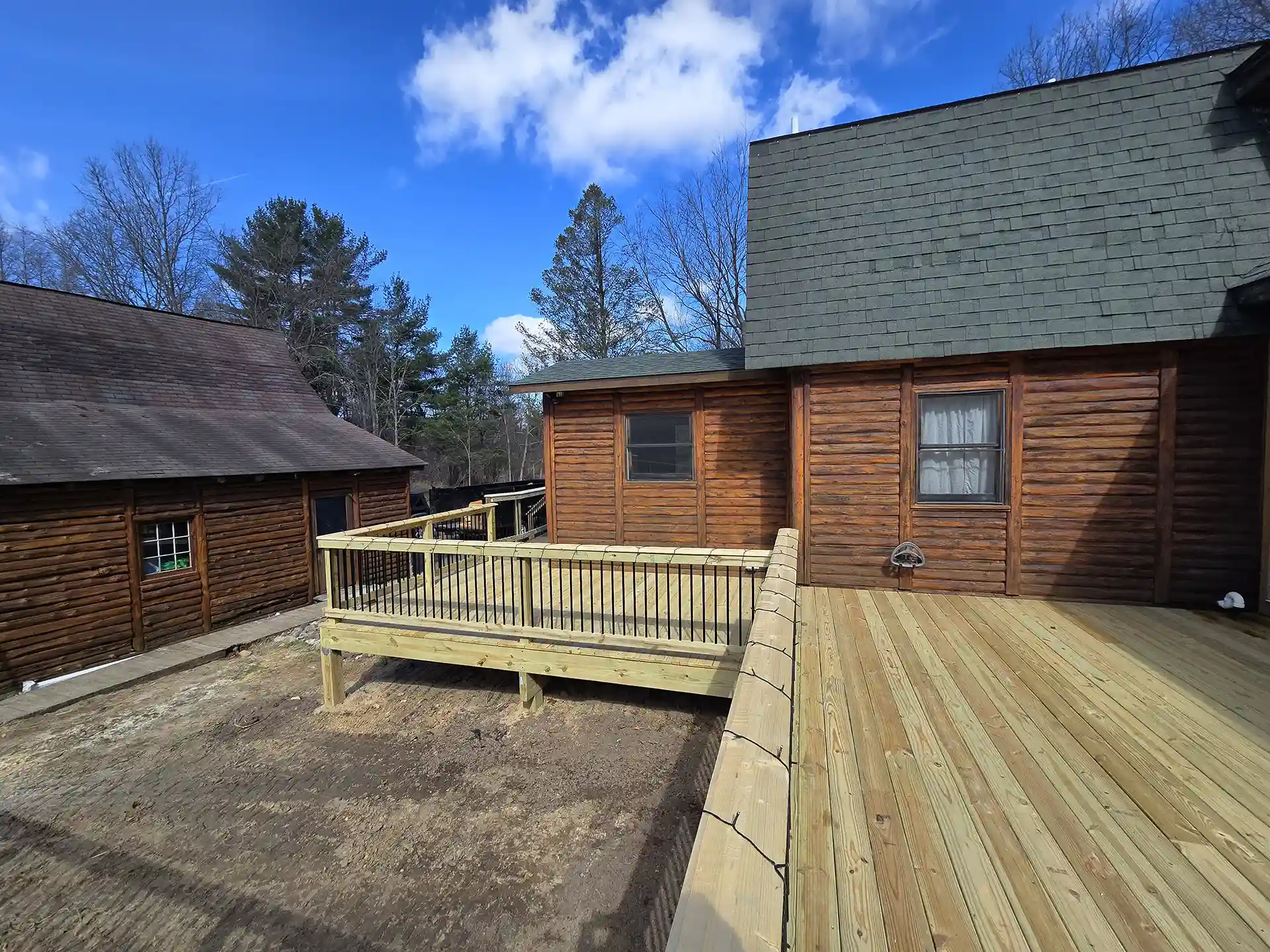 photo of a spacious, wraparound wooden deck with wooden railings