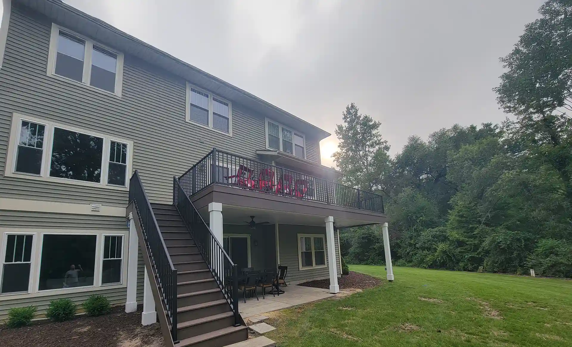 Photo of an elevated deck with patio below; deck railing, and deck stairs